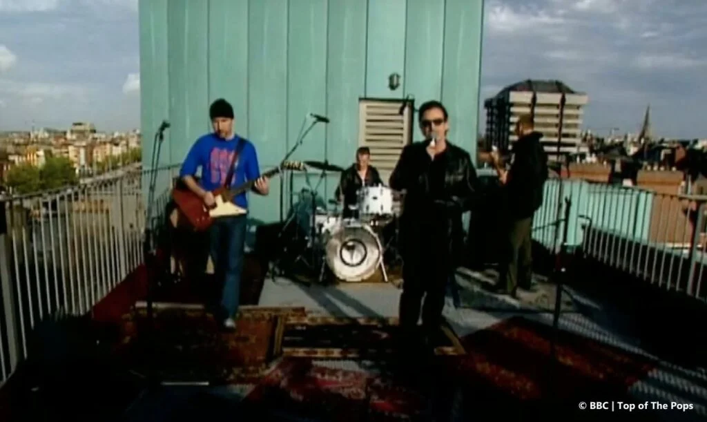U2 climb onto the roof of their own hotel and stop one bank of the Liffey